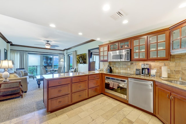 4-820 Kuhio Hwy Unit H304, Kapaa, HI 96746 - kitchen with stainless steel appliances, a peninsula, ornamental molding, decorative backsplash, and light stone counters