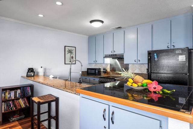 78-6665 Alii Dr Unit 302, Kailua-Kona, HI 96740 - kitchen featuring under cabinet range hood, black appliances, crown molding, tasteful backsplash, and a peninsula