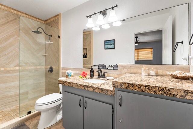 78-6665 Alii Dr Unit 302, Kailua-Kona, HI 96740 - full bathroom with walk in shower, vanity, tile walls, toilet, and ceiling fan