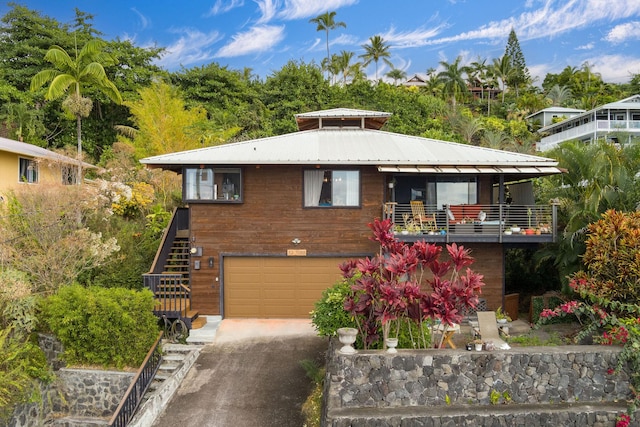 87-3188 Boki Rd, Captain Cook, HI 96704 - view of front of property with stairway, an attached garage, asphalt driveway, metal roof, and a balcony