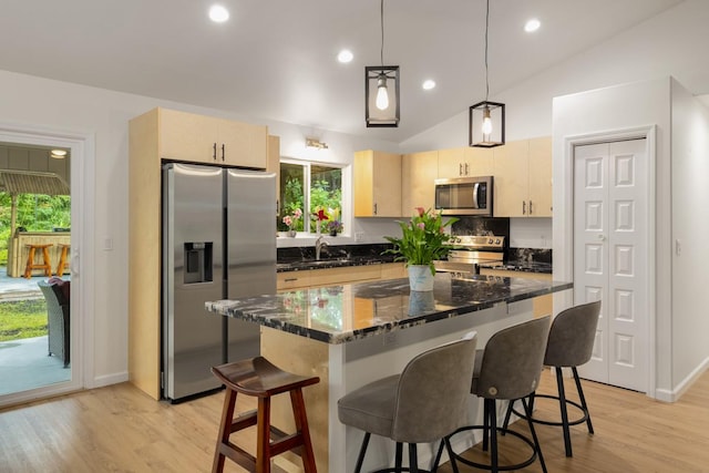 15-1798 20th Ave, Keaau, HI 96749 - kitchen with appliances with stainless steel finishes, a breakfast bar area, vaulted ceiling, light wood-style floors, and dark stone countertops