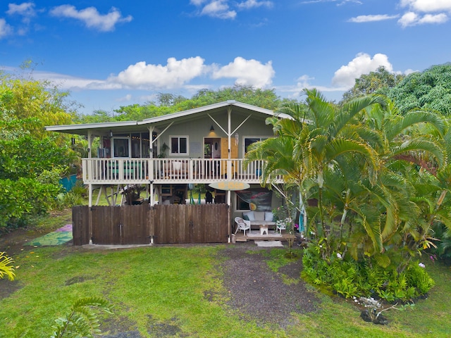15-1565 Beach Rd, Keaau, HI 96749 - view of front facade with a sunroom, a front yard, and a wooden deck