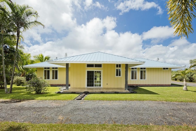15-1612 3rd Ave, Keaau, HI 96749 - rear view of house with board and batten siding, a lawn, and metal roof