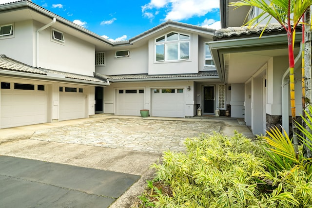 4100 Queen Emmas Dr Unit 64, Princeville, HI 96722 - view of front facade featuring an attached garage, stucco siding, driveway, and a tiled roof