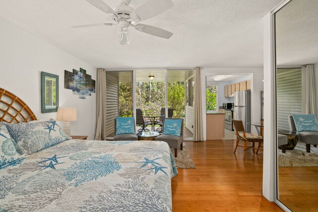 3811 Edward Rd Unit 1108, Princeville, HI 96722 - bedroom with access to outside, freestanding refrigerator, light wood-style flooring, a textured ceiling, and ceiling fan