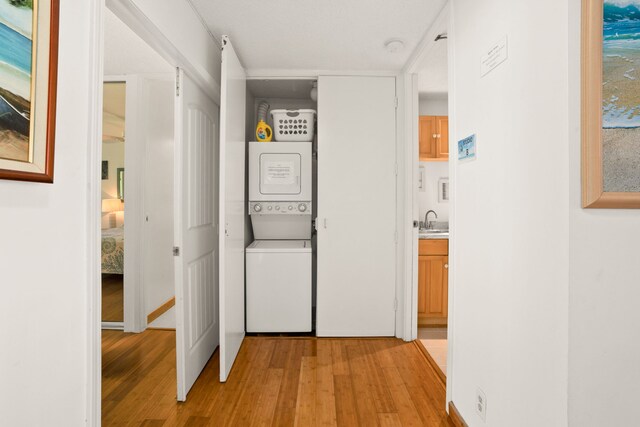 3811 Edward Rd Unit 1108, Princeville, HI 96722 - hall with stacked washing machine and dryer, light wood-style floors, and a sink