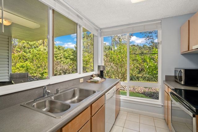 3811 Edward Rd Unit 1108, Princeville, HI 96722 - kitchen with appliances with stainless steel finishes, a sink, light tile patterned floors, plenty of natural light, and a textured ceiling