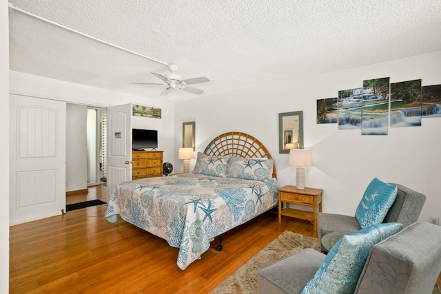 3811 Edward Rd Unit 1108, Princeville, HI 96722 - bedroom with a textured ceiling, wood finished floors, and a ceiling fan