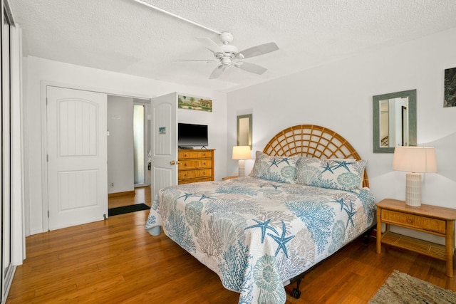 3811 Edward Rd Unit 1108, Princeville, HI 96722 - bedroom featuring wood finished floors, a textured ceiling, and a ceiling fan