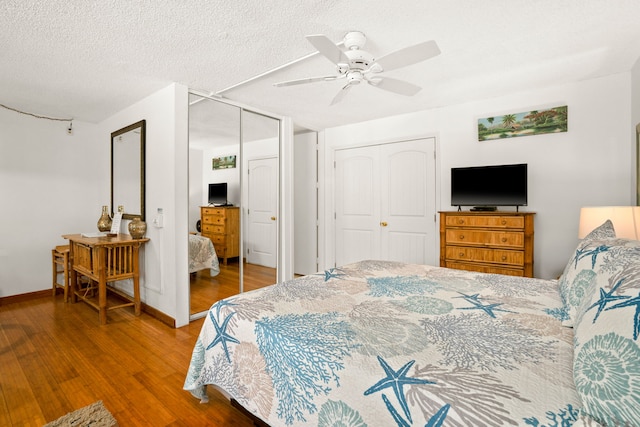 3811 Edward Rd Unit 1108, Princeville, HI 96722 - bedroom with wood finished floors, a ceiling fan, baseboards, and a textured ceiling