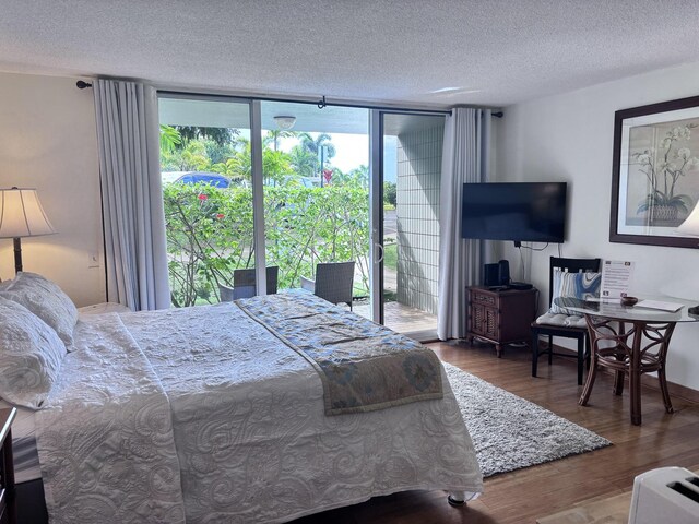 3811 Edward Rd Unit 1108, Princeville, HI 96722 - bedroom featuring floor to ceiling windows, access to outside, wood finished floors, and a textured ceiling