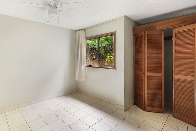 4701 Kawaihau Rd Unit A101, Kapaa, HI 96746 - unfurnished bedroom featuring light tile patterned flooring, a closet, ceiling fan, and a textured ceiling