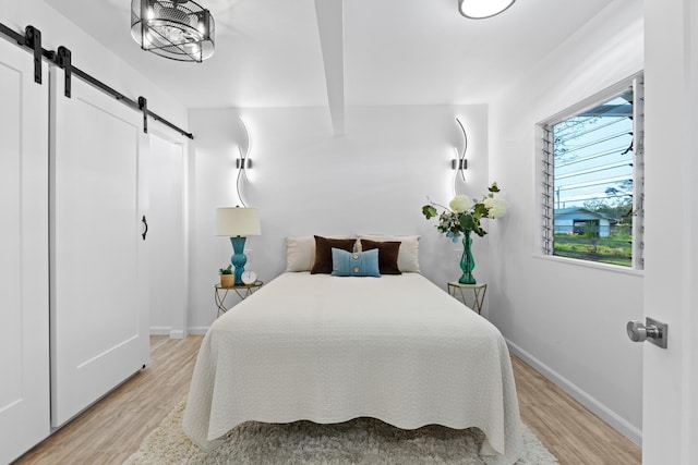 15-2774 Ahi St, Pahoa, HI 96778 - bedroom with a barn door, light wood-style floors, and baseboards