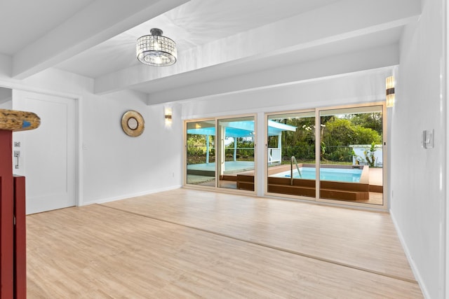 15-2774 Ahi St, Pahoa, HI 96778 - unfurnished room featuring plenty of natural light, beam ceiling, wood finished floors, and baseboards