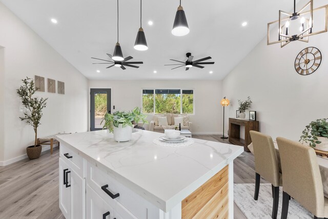 16-2050 Pikake Dr, Pahoa, HI 96778 - kitchen featuring lofted ceiling, light wood-style flooring, white cabinetry, light stone counters, and open floor plan