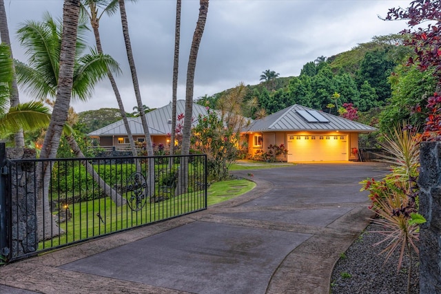 75-665 Kula Kai Pl, Kailua-Kona, HI 96740 - view of front of house featuring a standing seam roof, an attached garage, driveway, a metal roof, and stucco siding