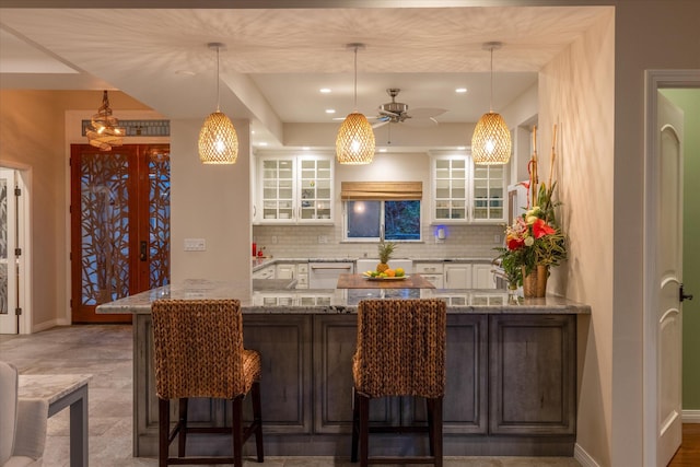 75-665 Kula Kai Pl, Kailua-Kona, HI 96740 - kitchen with ceiling fan, backsplash, white cabinets, a breakfast bar, and glass insert cabinets