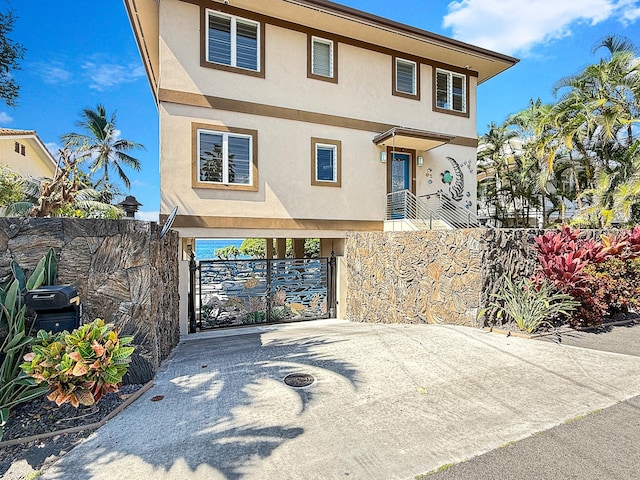 75-5952 Alii Dr, Kailua-Kona, HI 96740 - view of front of home with driveway, stucco siding, a carport, and a gate