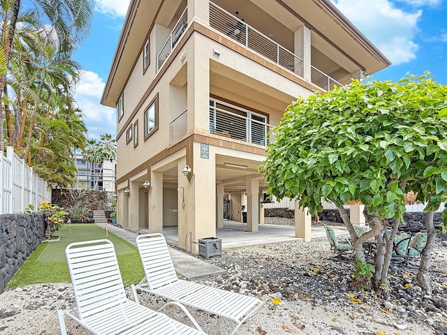 75-5952 Alii Dr, Kailua-Kona, HI 96740 - rear view of property with stucco siding, a patio area, a balcony, and a carport