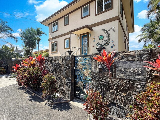 75-5952 Alii Dr, Kailua-Kona, HI 96740 - view of front facade featuring stucco siding and a gate