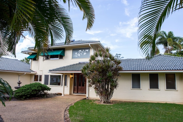 7021 Holo Pono Pl, Kapaa, HI 96746 - view of front of house with a tiled roof, driveway, and a front lawn