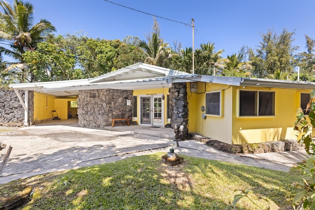 15-1913 Beach Rd, Keaau, HI 96749 - mid-century modern home with french doors, a carport, stone siding, driveway, and a front lawn
