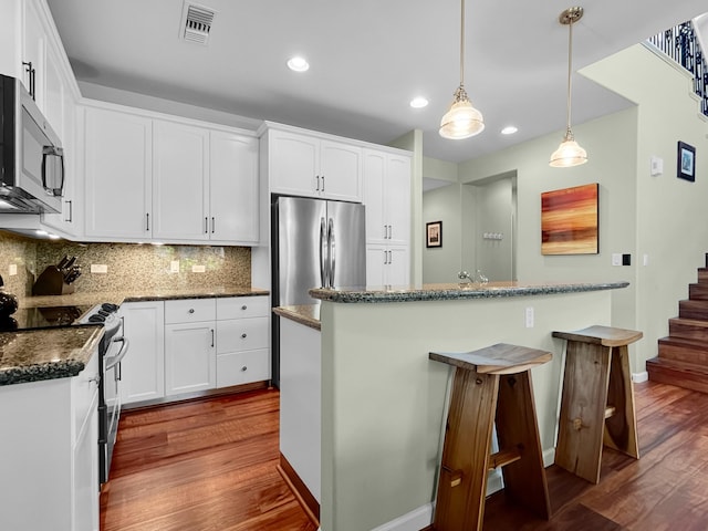 68-1125 Kaniku Dr Unit 1601, Kamuela, HI 96743 - kitchen with appliances with stainless steel finishes, dark wood finished floors, baseboards, backsplash, and recessed lighting