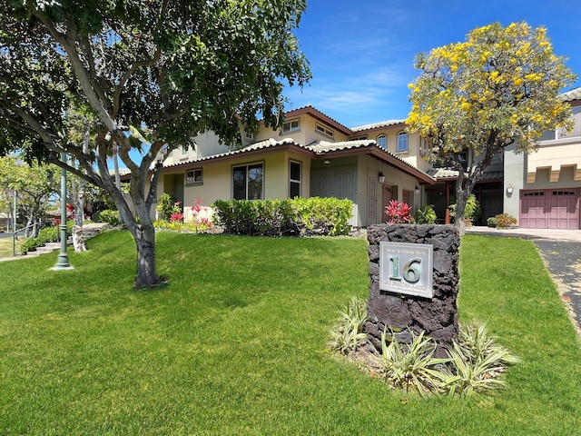 68-1125 Kaniku Dr Unit 1601, Kamuela, HI 96743 - mediterranean / spanish house featuring stucco siding, a front yard, a tiled roof, a garage, and driveway