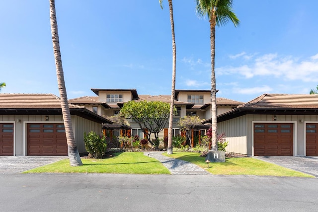 68-1122 Na Ala Hele Rd Unit H22, Kamuela, HI 96743 - view of front facade featuring board and batten siding, community garages, and a front yard