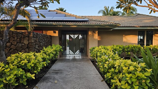 62-3600 Amaui Pl Unit 345, Waimea, HI 96743 - entrance to property with stucco siding, solar panels, and a tile roof