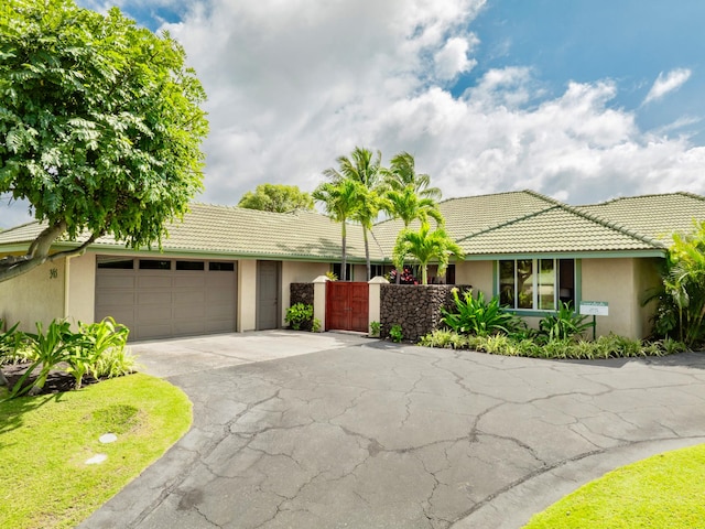 62-3600 Amaui Pl Unit 345, Waimea, HI 96743 - single story home featuring stucco siding, asphalt driveway, a garage, a tiled roof, and a gate