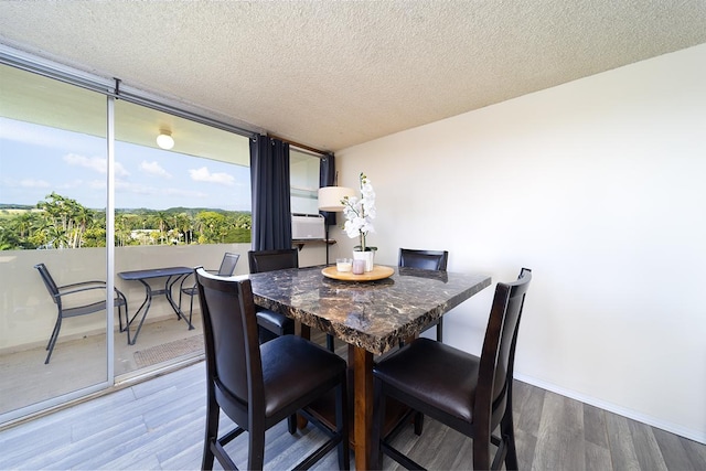 84 Pukihae St Unit 1106, Hilo, HI 96720 - dining room with wood finished floors, a textured ceiling, and baseboards