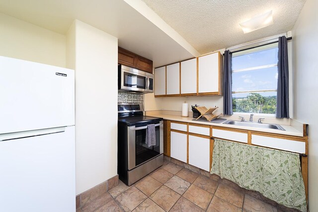 84 Pukihae St Unit 1106, Hilo, HI 96720 - kitchen featuring stainless steel appliances, light countertops, a sink, light stone finish flooring, and a textured ceiling