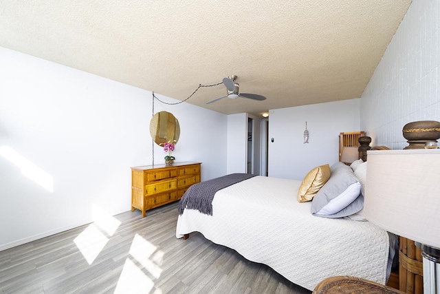 84 Pukihae St Unit 1106, Hilo, HI 96720 - bedroom featuring light wood-type flooring, a textured ceiling, and a ceiling fan
