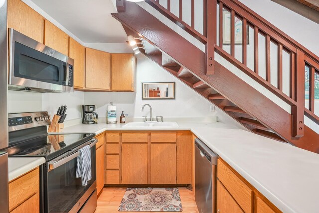 1901 Poipu Rd Unit 821, Koloa, HI 96756 - kitchen featuring appliances with stainless steel finishes, a sink, light wood-type flooring, and light countertops
