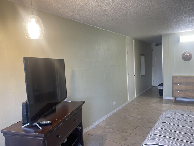 75-5776 Kuakini Hwy Unit 138, Kailua-Kona, HI 96740 - bedroom with light tile patterned floors, a textured ceiling, and baseboards