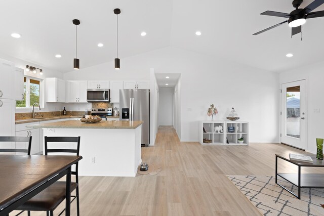 16-2072 Hapuu Dr, Pahoa, HI 96778 - kitchen with stainless steel appliances, a sink, vaulted ceiling, a center island, and light wood finished floors
