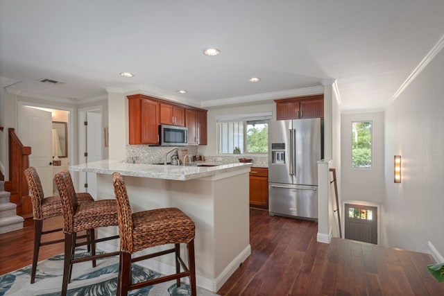 68-1122 Na Ala Hele Rd Unit A22, Kamuela, HI 96743 - kitchen with appliances with stainless steel finishes, a peninsula, dark wood-style flooring, decorative backsplash, and a kitchen breakfast bar