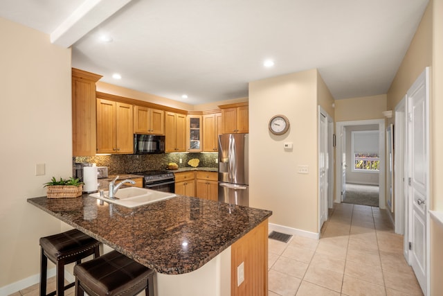 1831 Poipu Rd Unit 611, Koloa, HI 96756 - kitchen with black appliances, a sink, a peninsula, backsplash, and baseboards