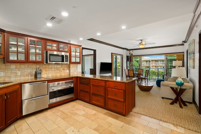 4-820 Kuhio Hwy Unit C205, Kapaa, HI 96746 - kitchen featuring appliances with stainless steel finishes, a peninsula, open floor plan, crown molding, and recessed lighting