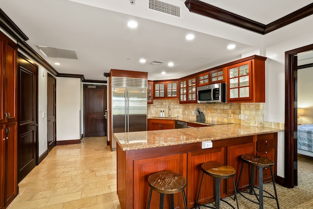 4-820 Kuhio Hwy Unit C205, Kapaa, HI 96746 - kitchen featuring stainless steel appliances, crown molding, tasteful backsplash, a peninsula, and light stone countertops
