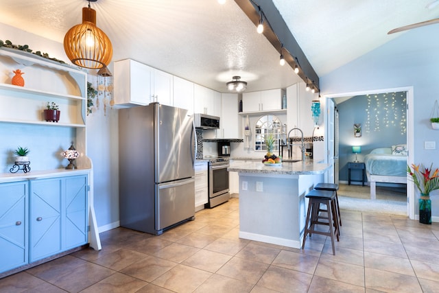 68-3890 Lua Kula St Unit 1007, Waikoloa, HI 96738 - kitchen with stainless steel appliances, a textured ceiling, a breakfast bar area, white cabinets, and a peninsula