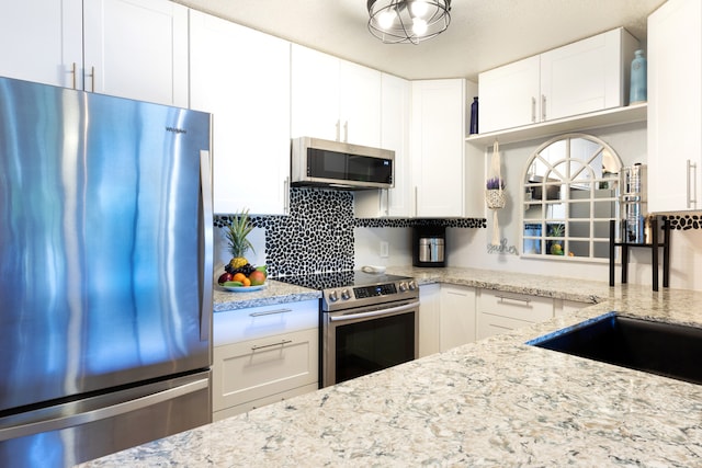68-3890 Lua Kula St Unit 1007, Waikoloa, HI 96738 - kitchen featuring appliances with stainless steel finishes, backsplash, white cabinets, light stone countertops, and a sink