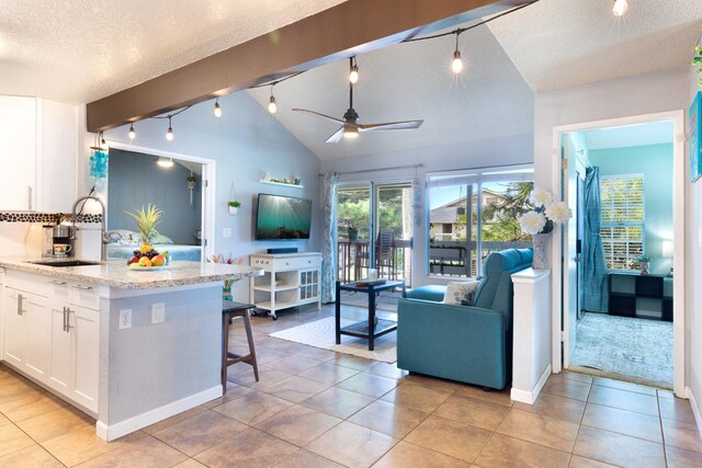 68-3890 Lua Kula St Unit 1007, Waikoloa, HI 96738 - kitchen with a sink, track lighting, white cabinets, open floor plan, and vaulted ceiling