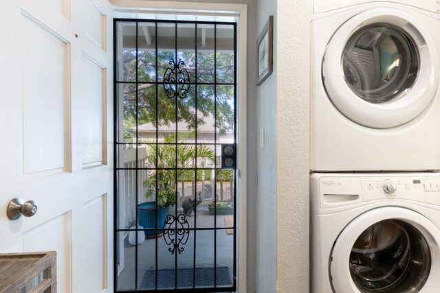 68-3890 Lua Kula St Unit 1007, Waikoloa, HI 96738 - washroom with stacked washing machine and dryer, a chandelier, and a textured wall
