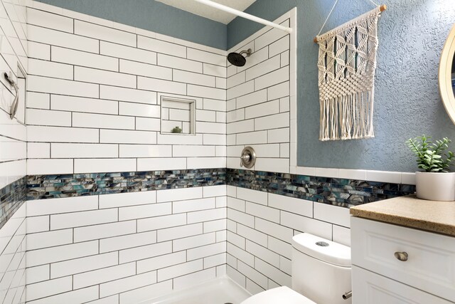 68-3890 Lua Kula St Unit 1007, Waikoloa, HI 96738 - bathroom featuring tiled shower, a textured wall, toilet, vanity, and tile walls