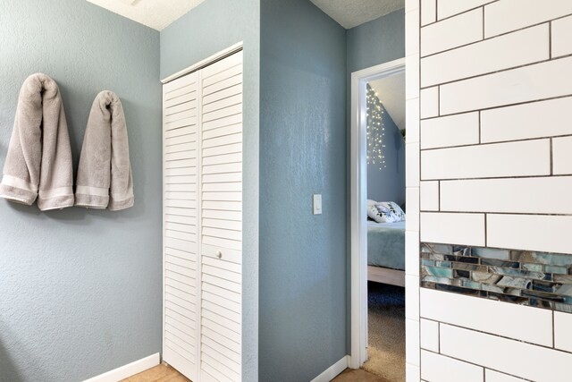 68-3890 Lua Kula St Unit 1007, Waikoloa, HI 96738 - bathroom with a textured wall, baseboards, a closet, and connected bathroom