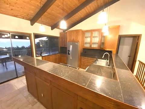 81-6315 Hawaii Belt Rd, Captain Cook, HI 96750 - kitchen with stainless steel refrigerator with ice dispenser, a sink, wooden ceiling, glass insert cabinets, and a peninsula