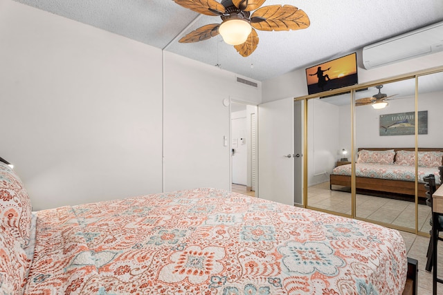 75-5719 Kona Plz Unit 203, Kailua-Kona, HI 96740 - bedroom with a wall unit AC, light tile patterned flooring, a textured ceiling, and ceiling fan