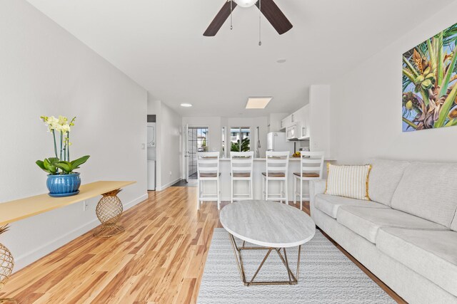 75-6081 Alii Dr Unit V106, Kailua-Kona, HI 96740 - living area featuring light wood-style floors, ceiling fan, and baseboards